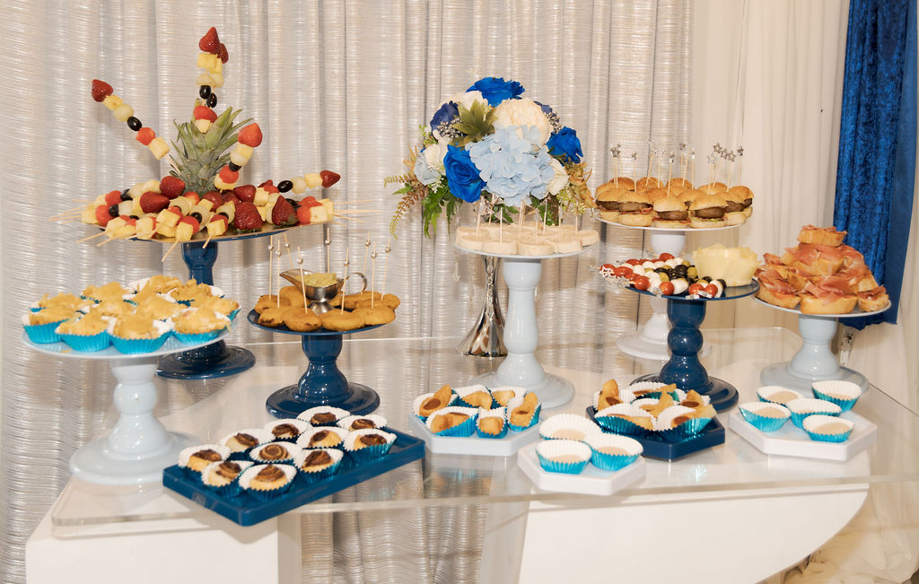 Mesa dulce con pasteles y dulces decorados en tonos azules para una fiesta de quince