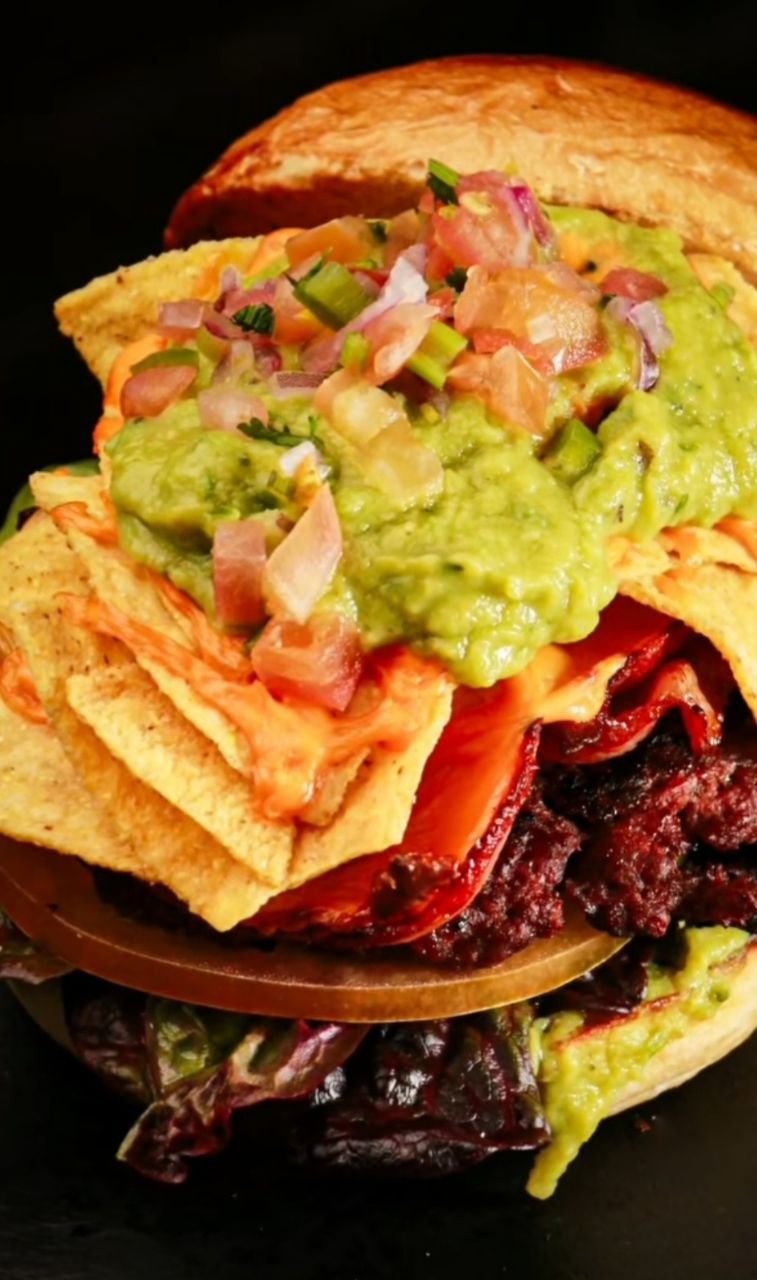Hamburguesa gourmet con guacamole y nachos fotografiada para la carta de un restaurante