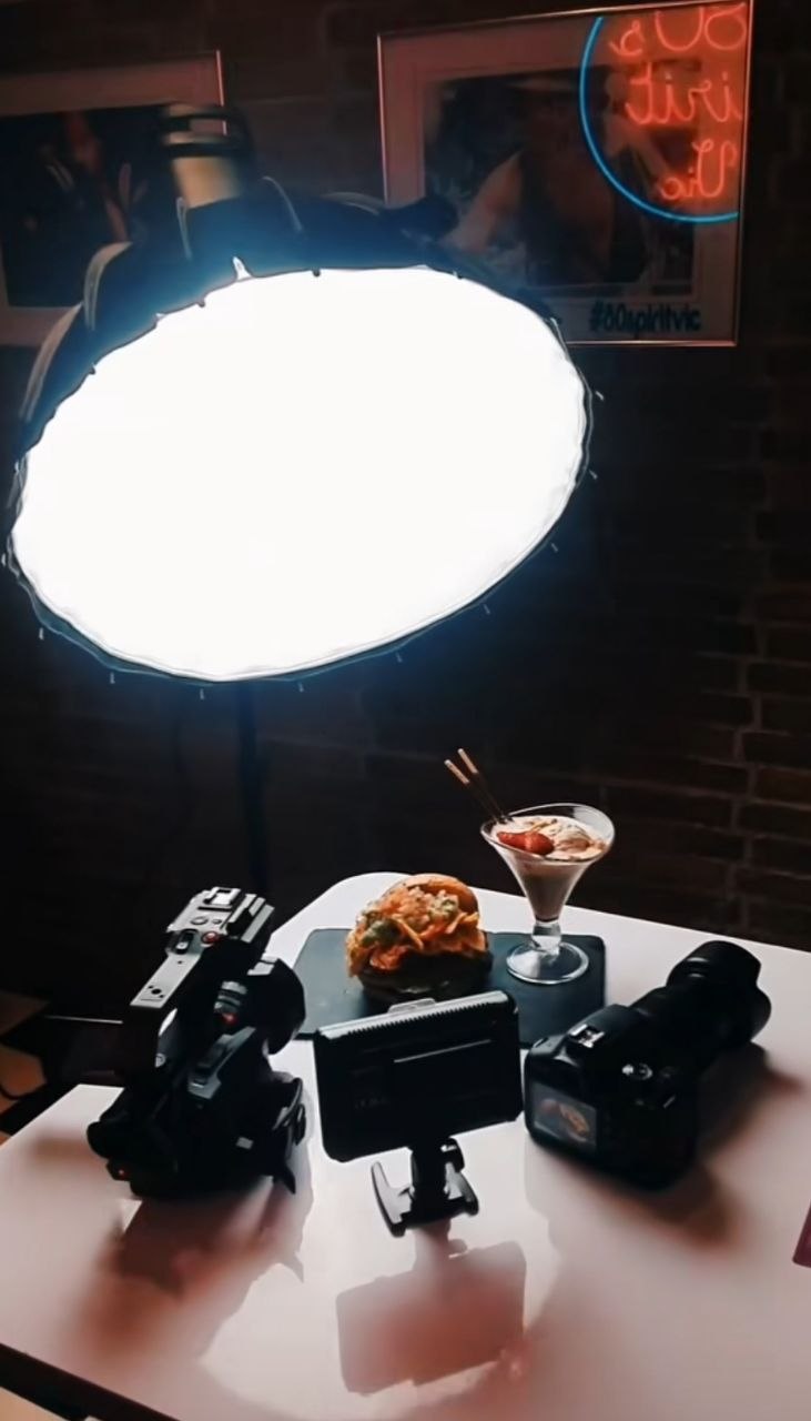 Set de fotografía de producto con softbox y cámaras iluminando un plato de restaurante